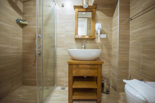a bathroom with a sink and a shower at Infinity City Hotel in Fethiye
