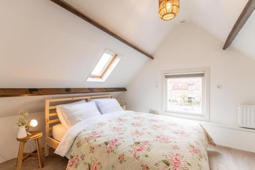 a bedroom with a large bed and a window at Vakantiewoning t Uusje Wemeldinge in Wemeldinge