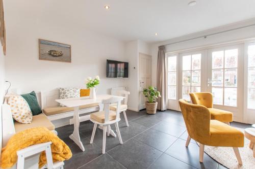 a living room with a couch and a table and chairs at Vakantiewoning t Uusje Wemeldinge in Wemeldinge