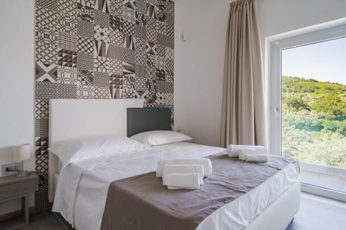 1 dormitorio con 1 cama y 2 toallas blancas en Cilento Victory House, en Serramezzana