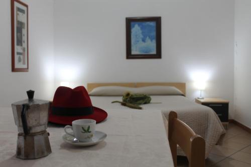 Una cama con dos sombreros y una taza sobre una mesa en Residence Sol Levante, en Frascati