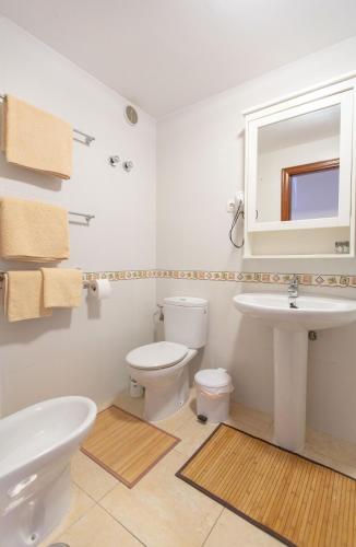 a white bathroom with a sink and a toilet at Casa Vivien in El Cotillo