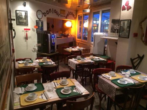 a restaurant with tables and chairs and a kitchen at Picardy Hôtel-Gare du Nord in Paris