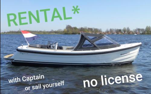 a small white boat on the water with no license at Lake house 21 relax accommodation iR Sauna in Warmond