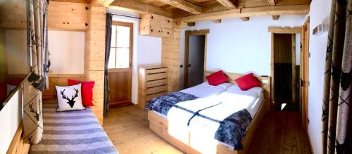 1 dormitorio con 1 cama en una cabaña de madera en Ciasa Coletin en Alvera