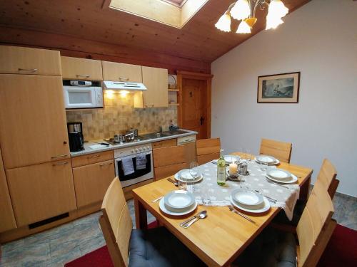 eine Küche mit einem Holztisch mit Stühlen und einem Esszimmer in der Unterkunft Ferienhaus Bergblick in Fulpmes