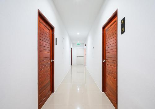 a corridor with two wooden doors and a white wall at The Beach at Klong Muang in Klong Muang Beach