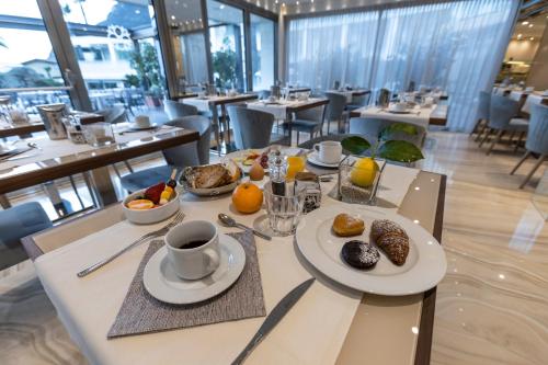 a table with plates of food and a cup of coffee at Park Hotel Imperial in Limone sul Garda