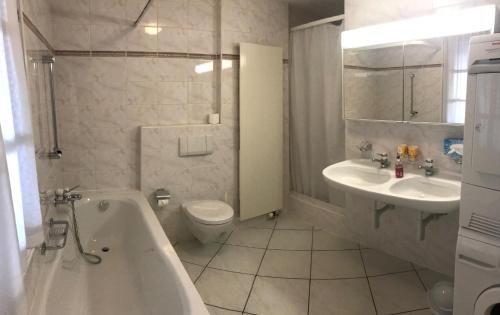 ein Badezimmer mit einer Badewanne, einem WC und einem Waschbecken in der Unterkunft Atelier 67 in Oberschan