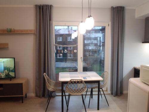 d'une salle à manger avec une table, des chaises et une fenêtre. dans l'établissement VP Kalamaja Apartment with garage, à Tallinn