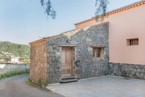 - un bâtiment en pierre avec une porte en bois dans l'établissement La 68, à Santa Brígida