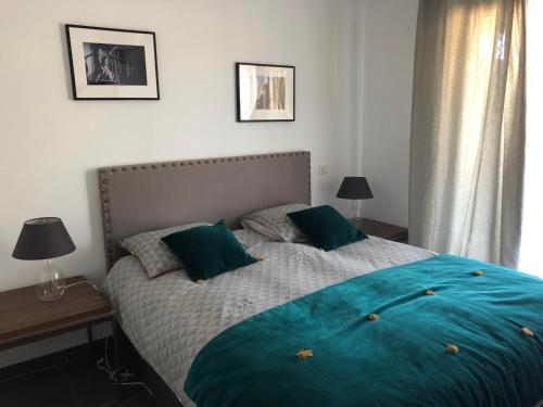 a bedroom with a large bed with green pillows at Appartements Porto-Piano in Propriano