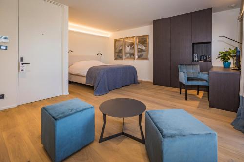 een hotelkamer met een bed, een tafel en een kruk bij Hotel De Jachthoorn in Hoogstraten