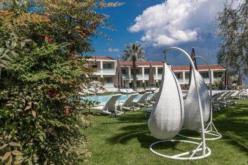 a row of lounge chairs next to a swimming pool at Park Hotel Imperial in Limone sul Garda