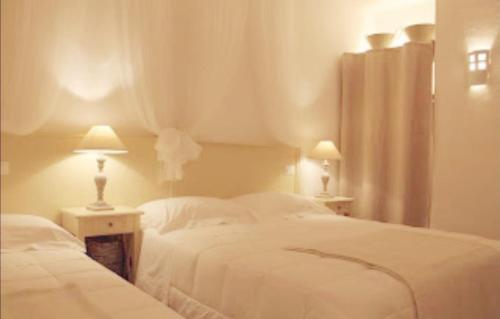 a bedroom with two white beds and two lamps at Le Nicchie Guest House in Lucera