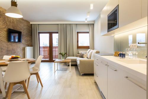 a kitchen and living room with a table and a couch at Royal Hill Residence in Zakopane