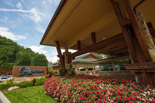 a hotel with a flower garden in front of a building at Greystone Lodge on the River in Gatlinburg