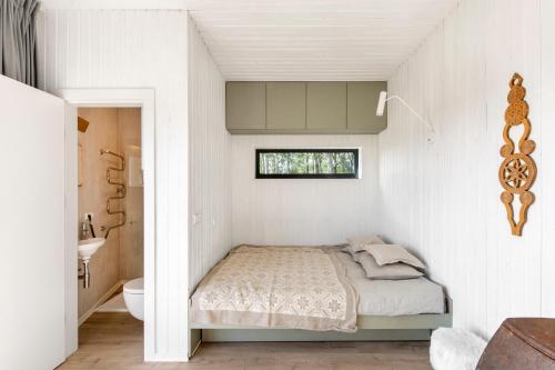 Pakalniškės的住宿－Etno Hut，一间小卧室,配有床和窗户