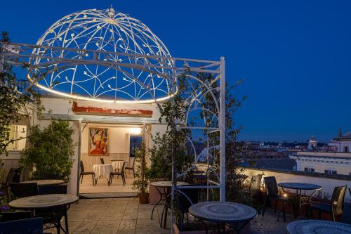 a patio with tables and chairs and a blue dome at Antica Dimora Delle Cinque Lune in Rome