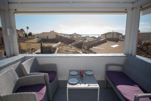 a balcony with two chairs and a table and a view at Aretusa Vacanze B&B in Siracusa