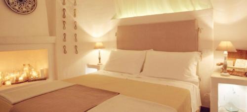 a bedroom with a large white bed with two lamps at Le Nicchie Guest House in Lucera