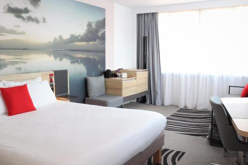 a hotel room with a large bed and a desk at Novotel Edinburgh Centre in Edinburgh