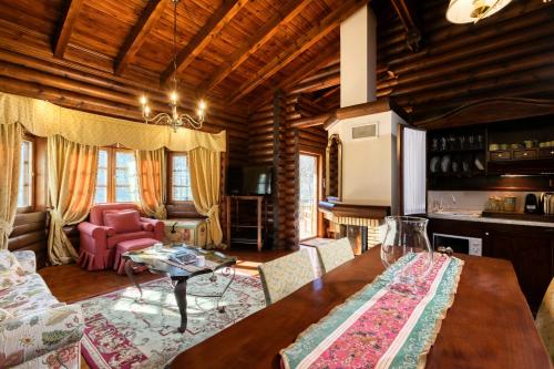 a living room with a table and a living room with a couch at All Seasons Paradise in Khrisovítsion