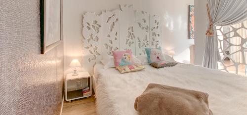 a small bedroom with a white bed with pillows at Un Appart En Ville "L'Alternative" in Annecy