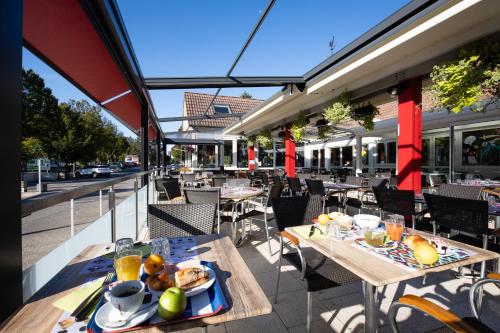 an outdoor restaurant with tables with food on it at Hotel-Restaurant Espace Squash 3000 in Mulhouse