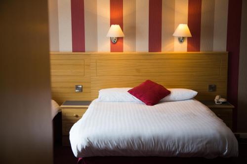 a hotel room with a bed with a red pillow at Viking Hotel- Adults Only in Blackpool