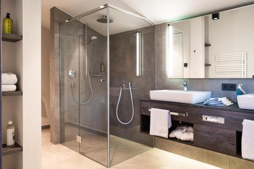 a bathroom with a glass shower and a sink at KaiserMoments in Going