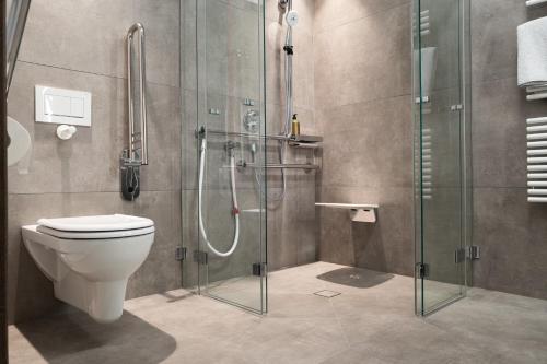 a bathroom with a toilet and a glass shower at KaiserMoments in Going