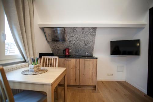 a kitchen with a wooden table and a table and a dining room at Luxury Suites Riverside Residence by Rikas Hotels in Antwerp