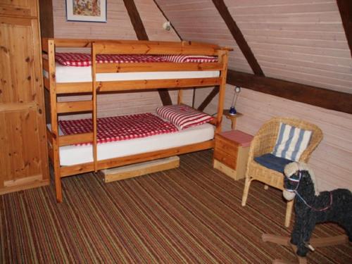 a bedroom with two bunk beds and a chair at Lindenhof in Ahneby