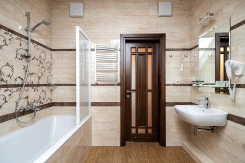 a bathroom with a tub and a sink and a bath tub at Chalet du Mont in Bukovel