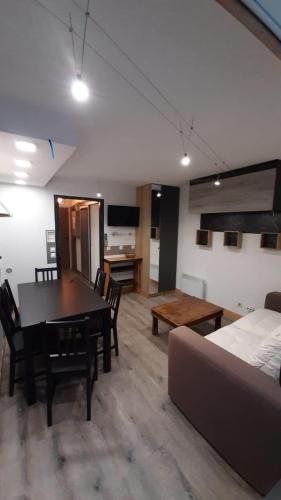 ein Wohnzimmer mit einem Bett, einem Tisch und Stühlen in der Unterkunft appartement luxe Vars pied des pistes 6 couchages in Vars