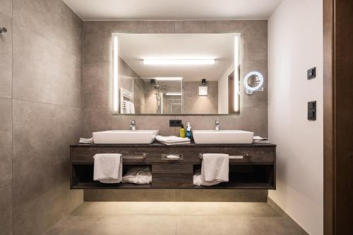 a bathroom with two sinks and a large mirror at KaiserMoments in Going
