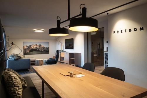 a conference room with a wooden table and two lights at KaiserMoments in Going