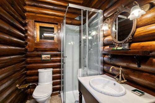 a bathroom with wooden walls and a toilet and a sink at All Seasons Paradise in Khrisovítsion