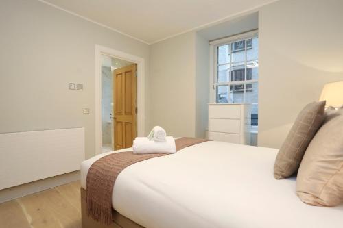 a bedroom with a large bed with a towel on it at ALTIDO Modern and Airy flat on the Historic Royal Mile in Edinburgh