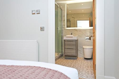 a bathroom with a sink and a toilet and a mirror at JOIVY Modern and Airy flat on the Historic Royal Mile in Edinburgh