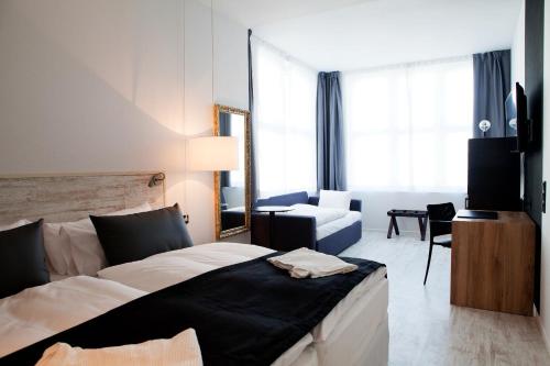 a bedroom with a large bed and a living room at Catalonia Berlin Mitte in Berlin
