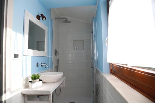 La salle de bains est pourvue d'un lavabo blanc et d'un miroir. dans l'établissement B&B Greenmind, à San Dorligo della Valle