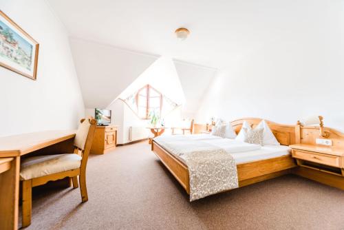 a bedroom with a wooden bed and a desk at Das Herbst in Feldbach