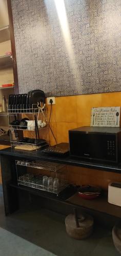 a table with a counter top with a microwave at Hebbar's Heritage Home in Mumbai