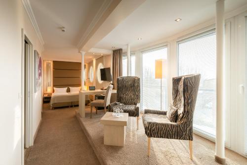 a hotel room with a bedroom and a living room at Thomas Hotel Spa & Lifestyle in Husum