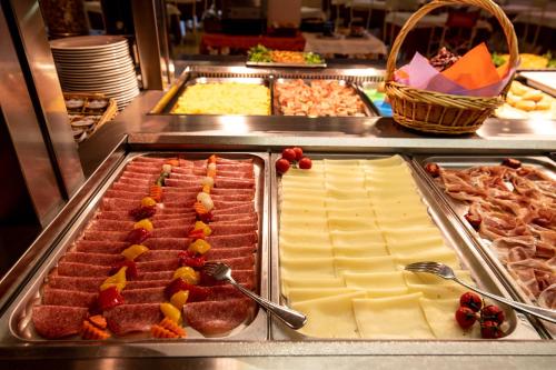 una línea de buffet con diferentes tipos de carne y queso en Hotel Parigi, en Caorle