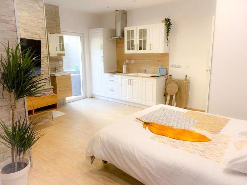 La Roche-BlancheLe Menhir 2 Jacuzzi Spa Terasse Barbecue的一间白色卧室,配有床和厨房