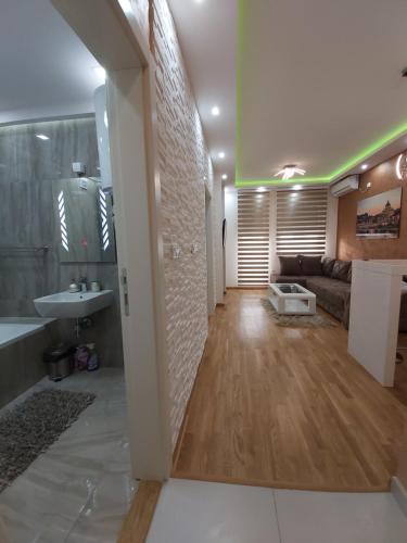 baño grande con bañera, lavamanos y sofá en Apartman Elegance Free Garage, en Novi Sad