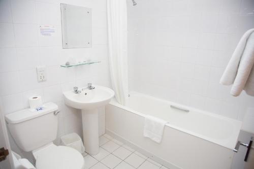 Claremont Hotel في بلاكبول: حمام ابيض مع مرحاض ومغسلة